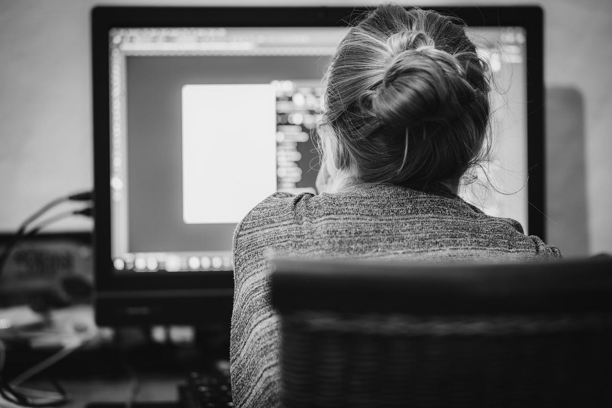 Une femme travaille sur un ordinateur, codant dans un environnement professionnel Une femme travaille sur un ordinateur, codant dans un environnement professionnel