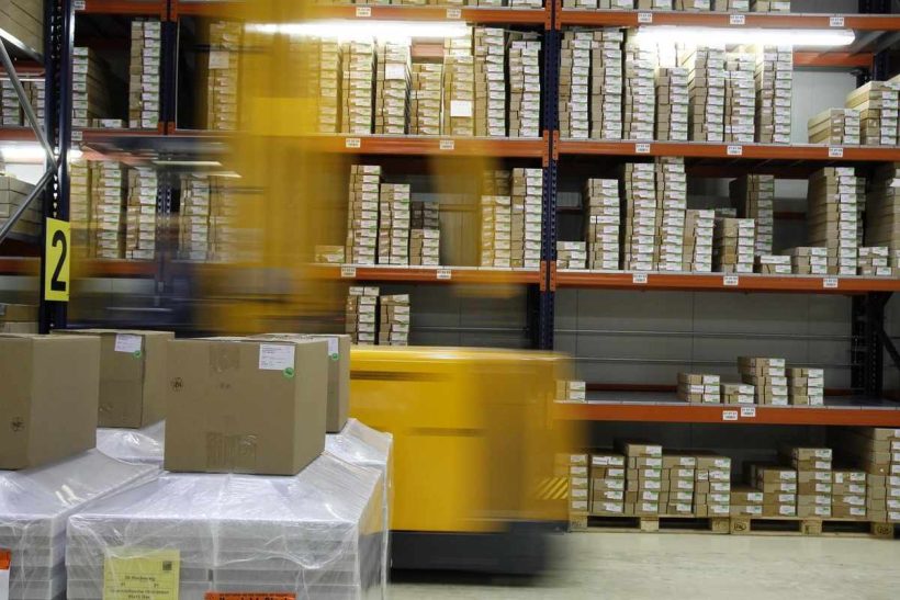Charriot jaune dans un entrepôt avec des étagères de cartons